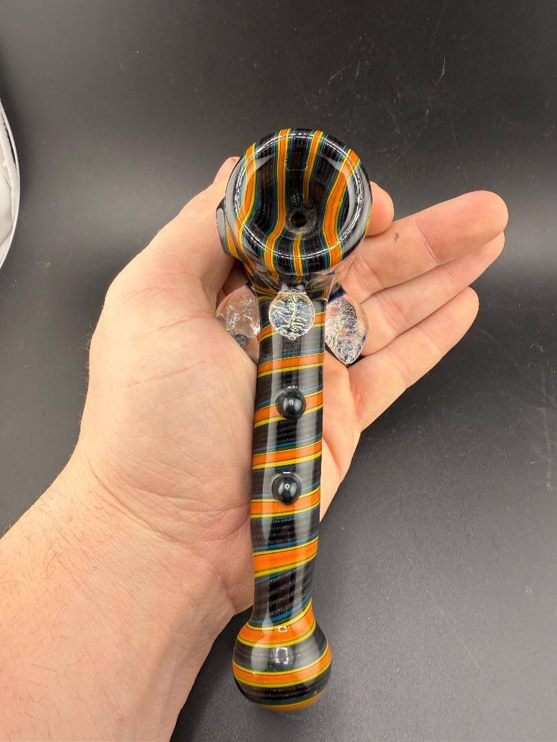 Filla John Glass Hammer Pipe - Orange & Black Line Worked w/ Dichro Attachments being held in hand.