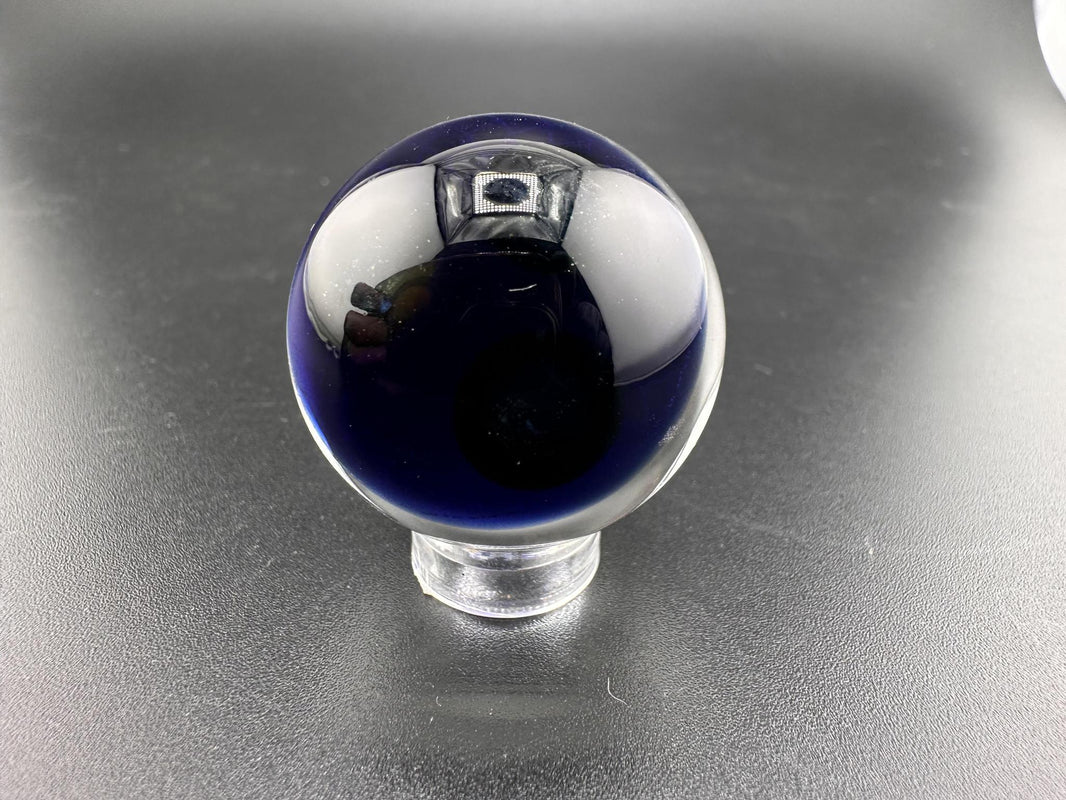 Filla John Glass Marble - Dichroic Sacred Geometry on a black surface, showcasing intricate design and radiant shimmer.