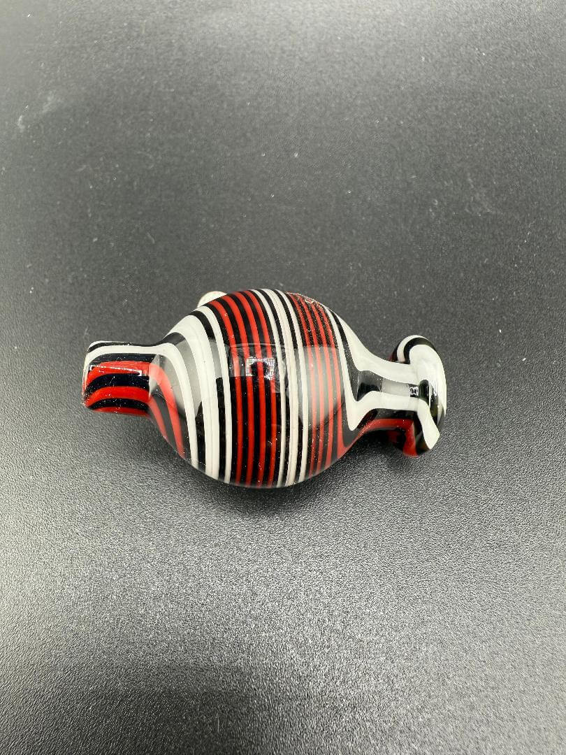 Filla John Glass  White, Black & Red Line Worked Bubble cap on a black surface.
