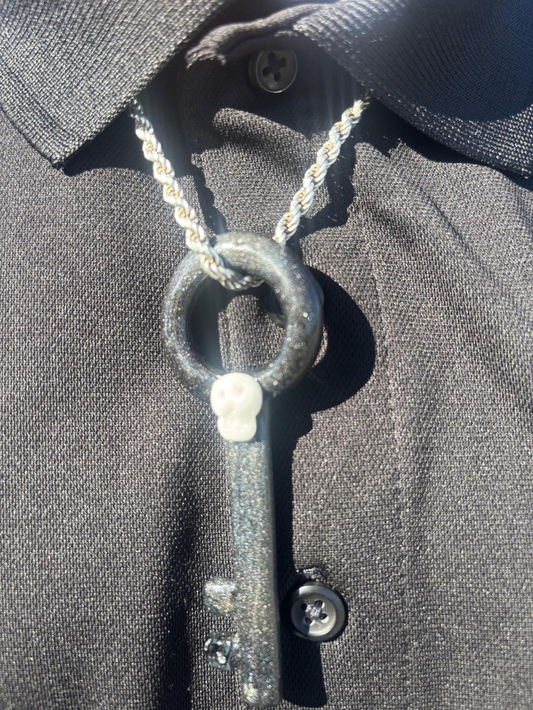 Filla John Key with Skull Pendant showcased on a black shirt, highlighting its unique design and artistry.