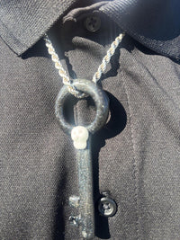 Filla John Key with Skull Pendant showcased on a black shirt, highlighting its unique design and artistry.