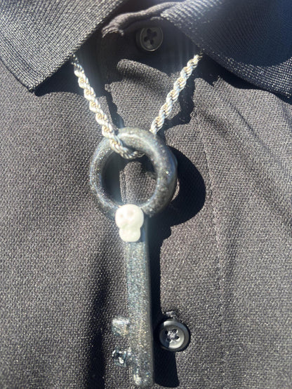 Filla John Key with Skull Pendant worn on a black shirt, showcasing the intricate key and skull design.