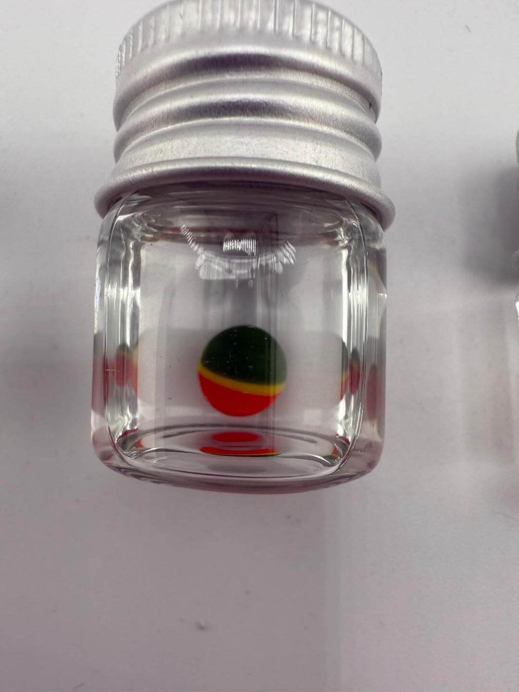 Clear glass container with colorful Pokeball design at the bottom, ideal for storing dab accessories.