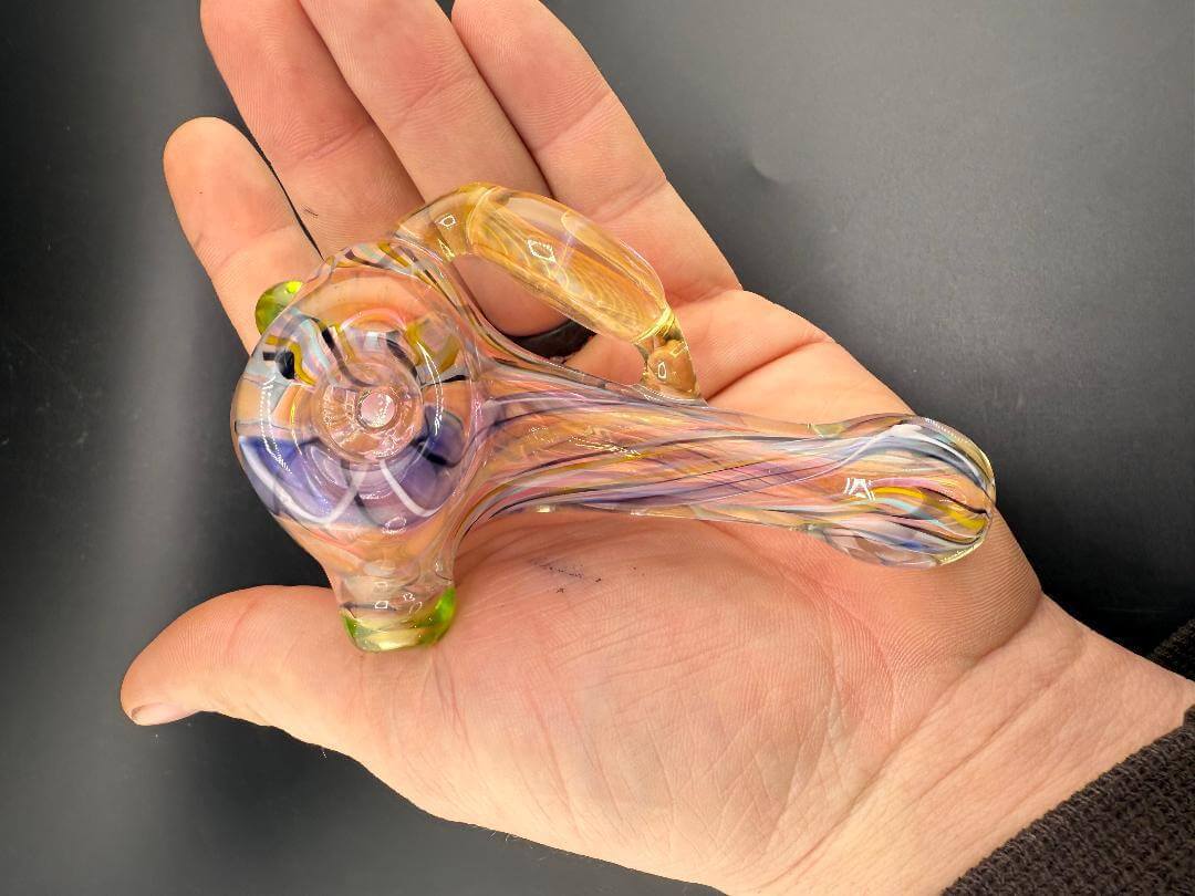 Guido Glass Hammer Pipe - Multi Colored Line work w/ Fumed Pendant held in hand showing vibrant design.