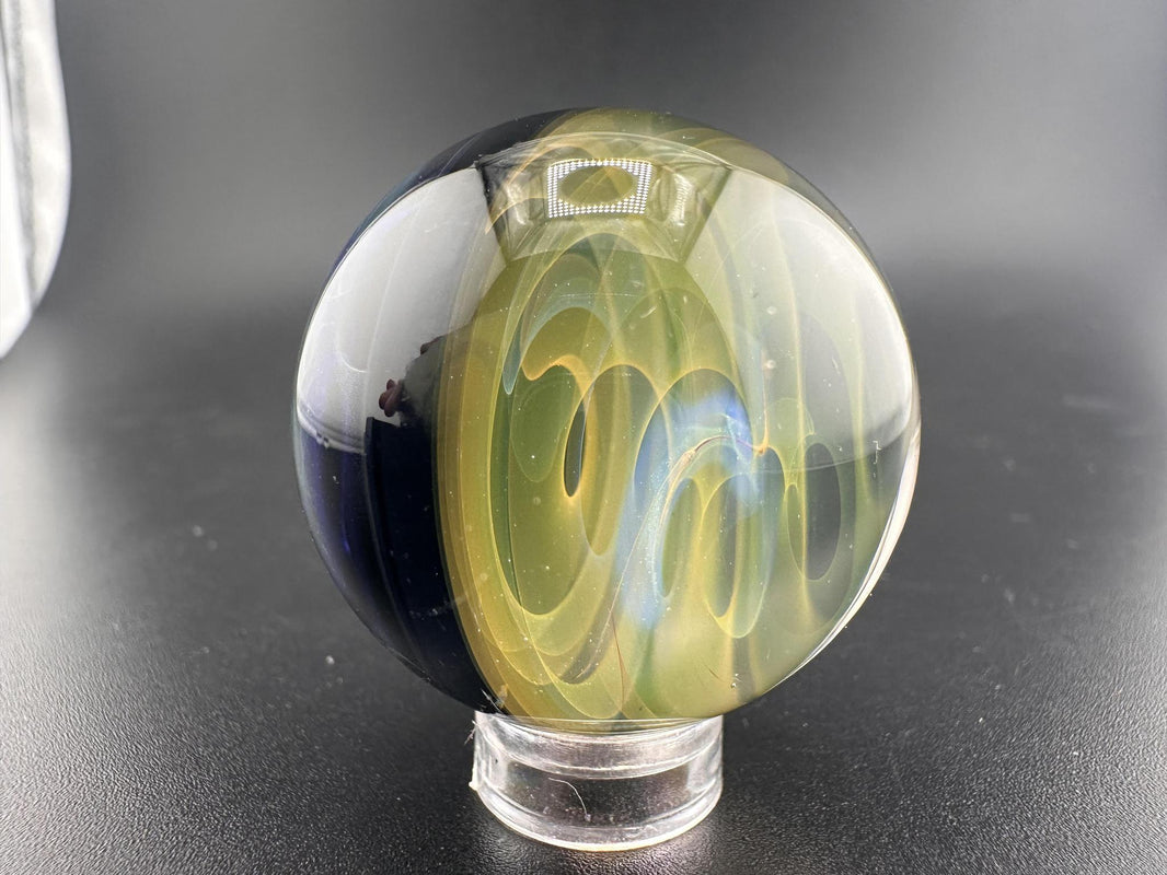 Guido Glass Marble - Chaos Backed Fumed Swirl showcasing swirling colors and expert craftsmanship, 1 inch handcrafted piece.