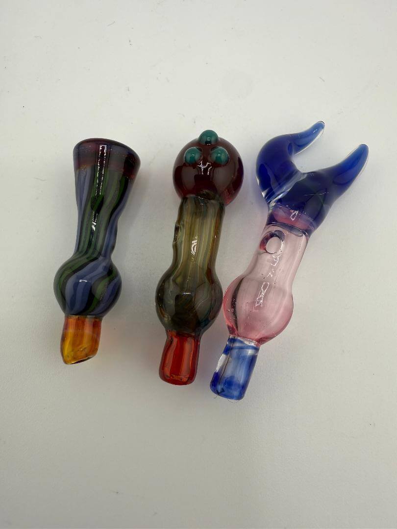Three handcrafted glass pipes in various shapes and colors for concentrate use.
