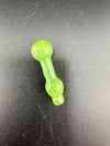 Colorful green and yellow glass hand pipe on a black surface.