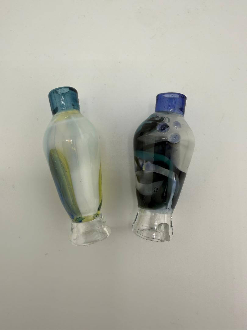 Two handcrafted glass pieces featuring vibrant colors and unique designs, showcasing artistic flair.
