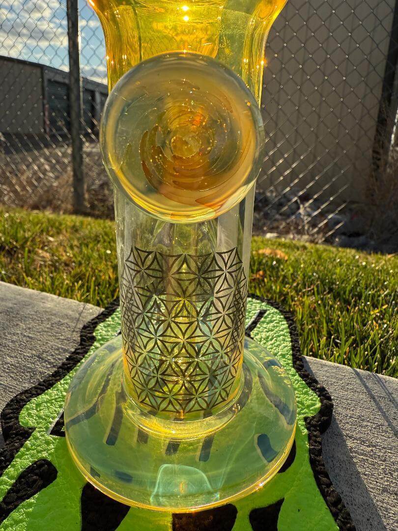 Highgrade Glass Flower Straight Tube - Fumed Bowl & Downstem w/ Sacred Geometry Bake Ons 14mm 45° showcasing intricate design in outdoor setting.
