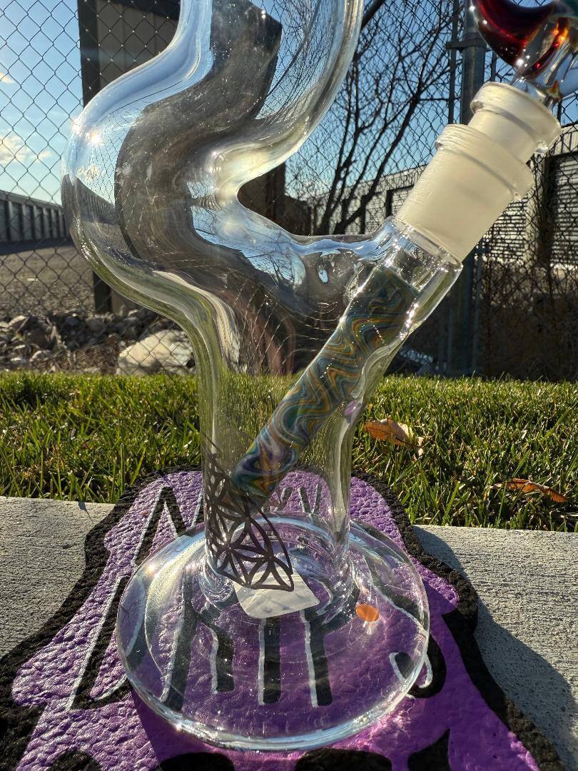 Highgrade Glass Flower Straight Tube - Rainbow & Amber Wig Wag Color Color Accent Pistol Loop 14mm 45° in outdoor setting.