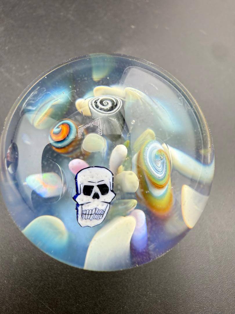 Highgrade Glass Marble - 38mm Skull Millie Implosion features a colorful skull design and vibrant millie implosion pattern.