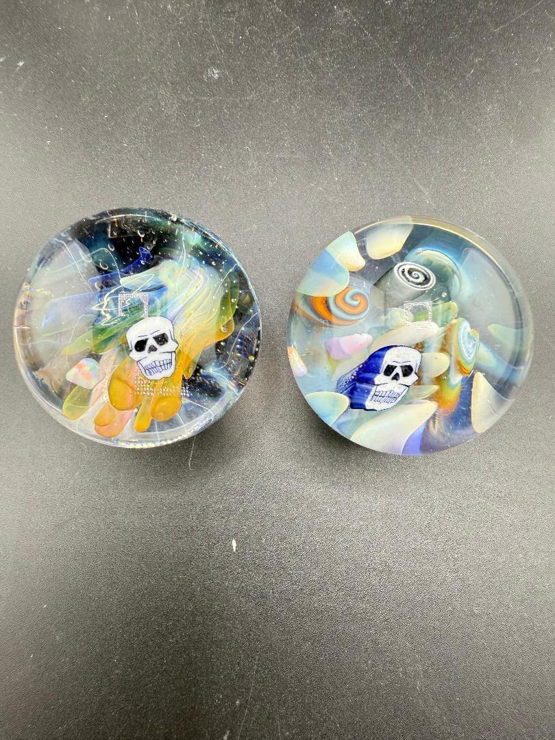 Highgrade Glass Marble - 38mm Skull Millie Implosion displayed in two colorful designs with vibrant details.