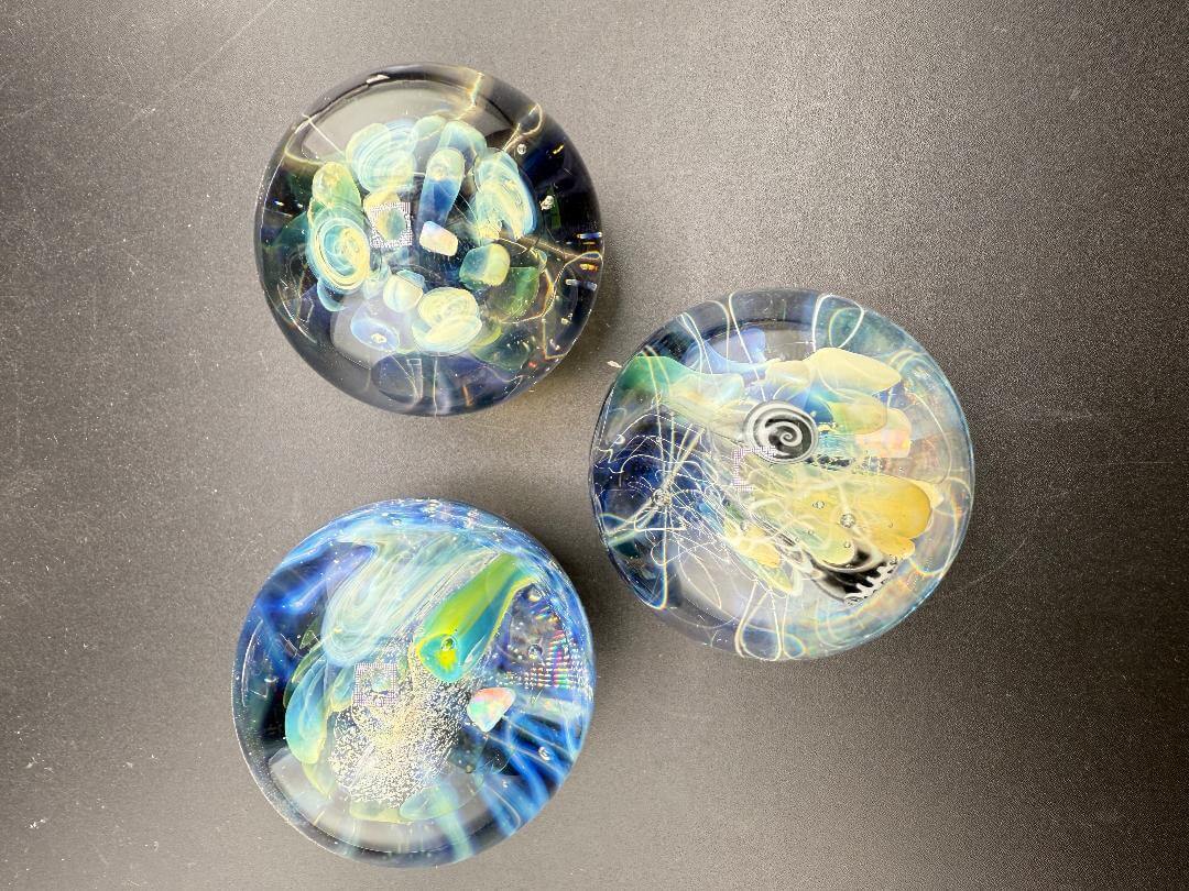 Highgrade Glass Marble - 40mm Millie Implosion w/ Opal Incasment displayed in a collection of three unique designs.