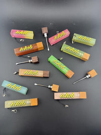 Collection of colorful Idab Dabber Guard tools for concentrate sessions laid out on a black background.