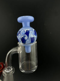 Import Bubble Cap 25mm - Dot Stack on a flat-top quartz banger, featuring intricate blue and white swirl design.