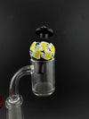 Import Bubble Cap 25mm - Dot Stack on a quartz banger, featuring a vibrant yellow and black swirl design.