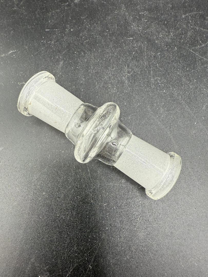 Import Glass 10mm Female To 10mm Female Adapter on a dark background, showcasing its borosilicate glass design.