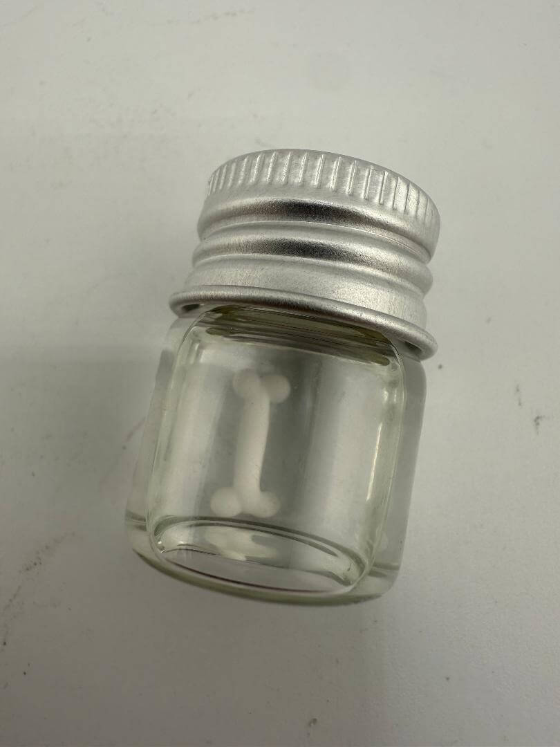 Lucky Gnome Glass Terp Pearl in a clear jar with silver lid, showcasing a bone-shaped design for dabbing.