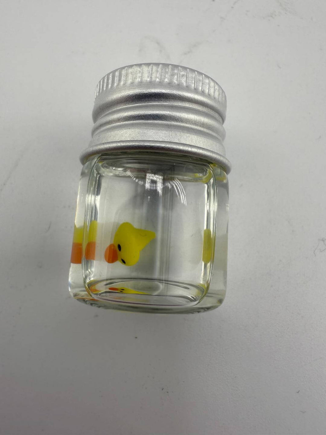 Lucky Gnome Glass Terp Pearl - Ducky in clear glass jar with silver lid, featuring a cute yellow duck design.