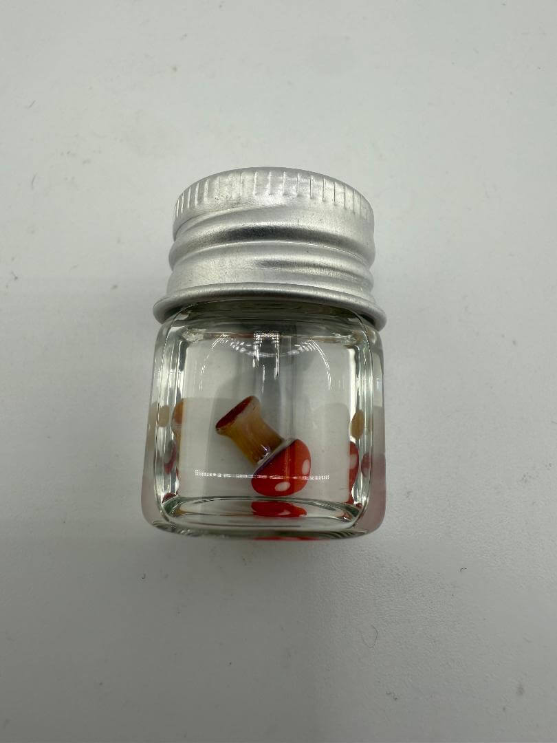 Lucky Gnome Glass Terp Pearl - Mushroom in a clear jar with silver lid, showcasing vibrant colors and whimsical design.
