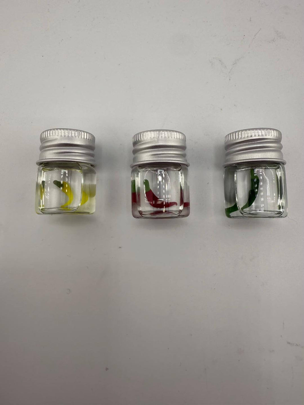 Three Lucky Gnome Glass Terp Pearls in jars - yellow, red, and green pepper designs for enhanced dab sessions.