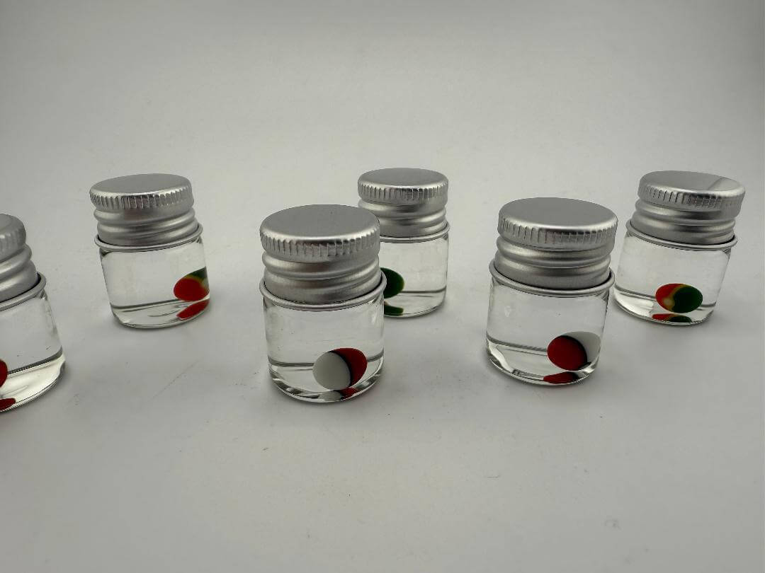 Lucky Gnome Glass Terp Pearl Pokeball in clear jars, colorful pearls for enhancing dabbing experience.