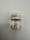 Clear glass jar with silver lid containing a white and red spotted terp pearl.