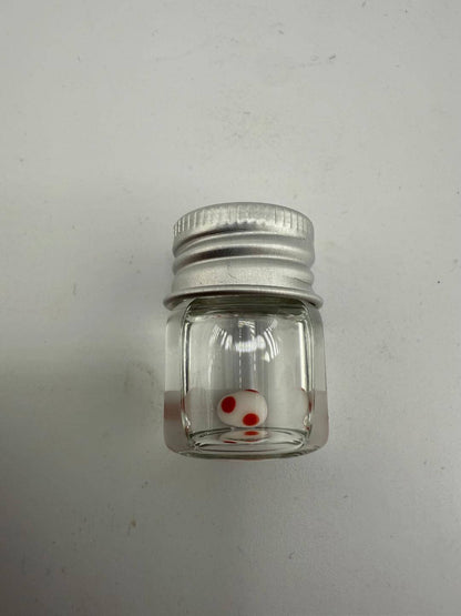 Clear glass jar with silver lid containing a white and red spotted terp pearl.