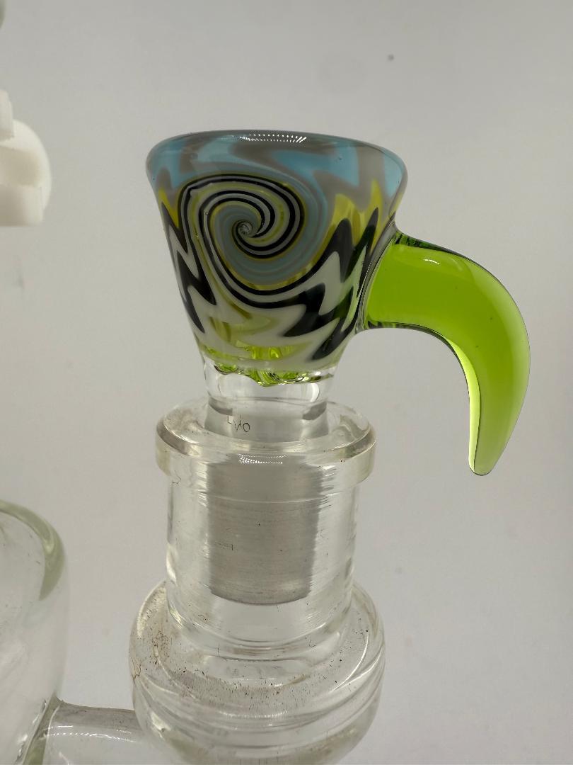 Handcrafted glass bowl with colorful swirl pattern and green handle, designed for smooth pulls and stylish use.