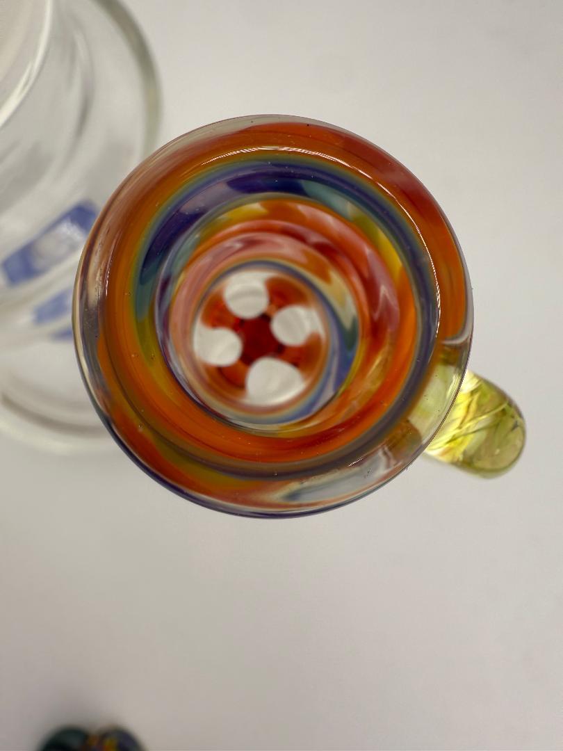 Close-up view of colorful artisan glass featuring vibrant swirls and patterns from the top perspective.