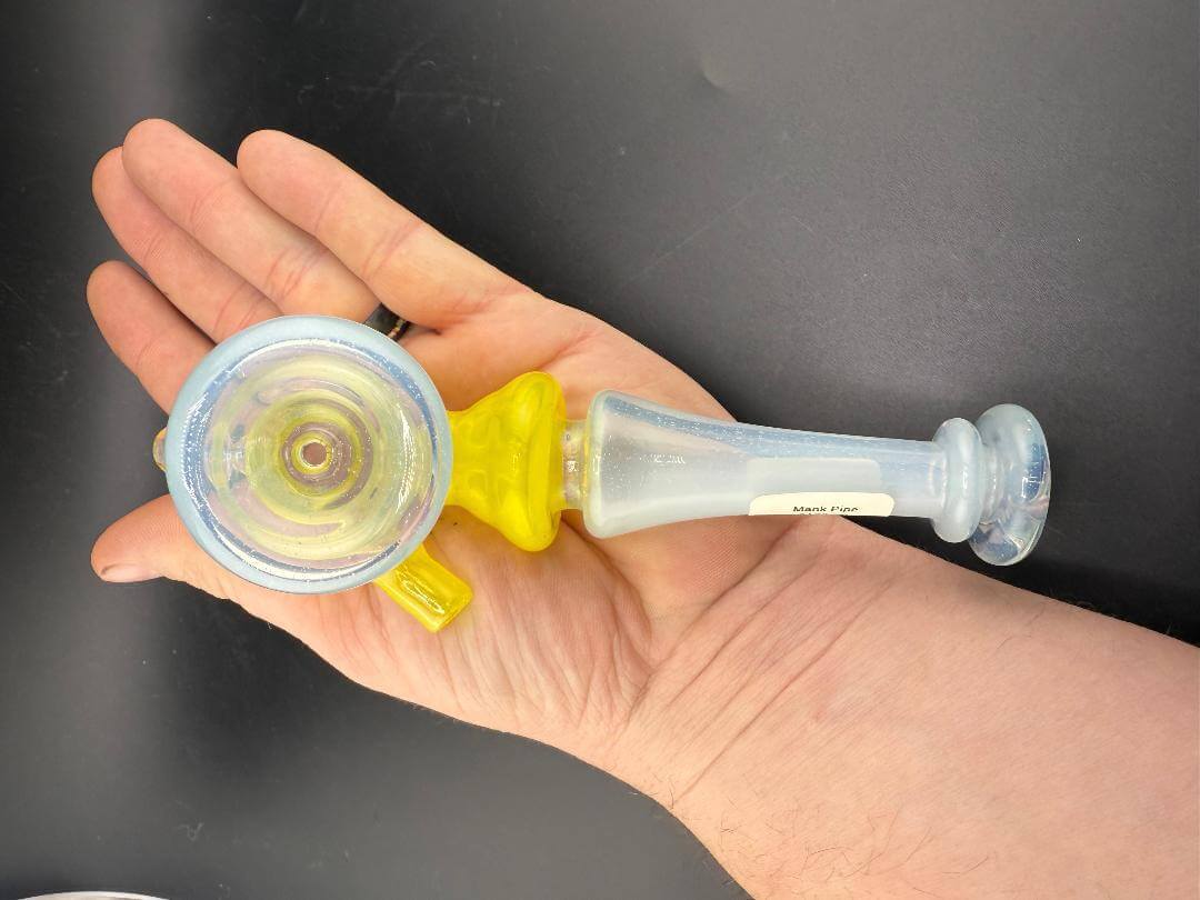 Mank Glass Hammer Pipe - Light Blue & Yellow w/ Encased Opal held in hand, showcasing vibrant colors and design.