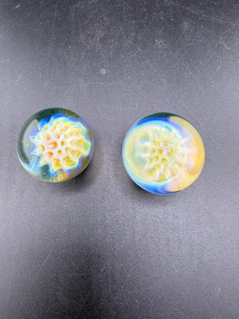 Mank Glass Marble Fumed Honeycomb Implosion 1.2" showcasing vibrant colors and unique patterns in two handcrafted pieces.
