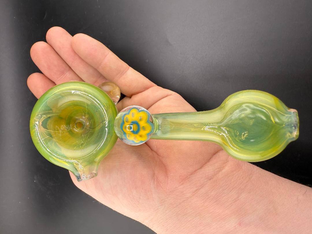 Mank Glass Sherlock Pipe - Green w/ Skull Millie shown in hand, showcasing vibrant green body and skull millie detail.