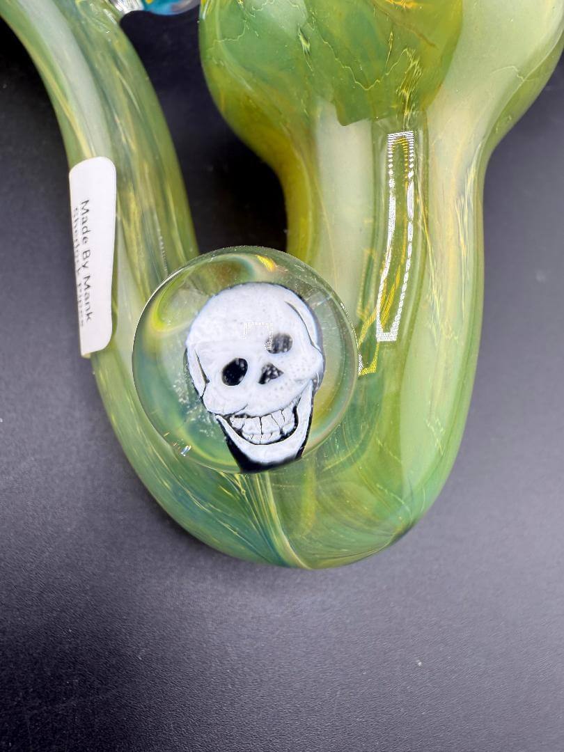 Mank Glass Sherlock Pipe - Green w/ Skull Millie showing artistic skull millie detail on vibrant green glass.