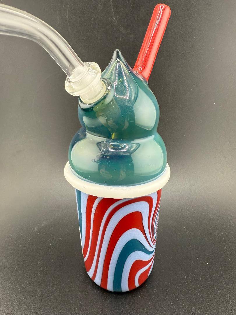 Image of the Matthew R Glass Terpee Rig 10mm 45° featuring a vibrant red and blue swirl design and a unique slurpee appearance.