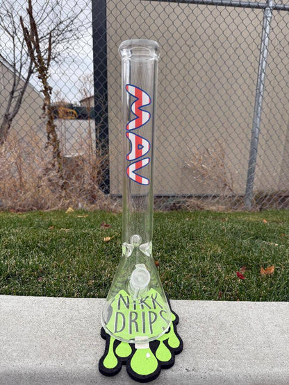 MAV Glass "18 Beaker 14mm 45° - American Flag" showcased on a green grass background with a unique base design.