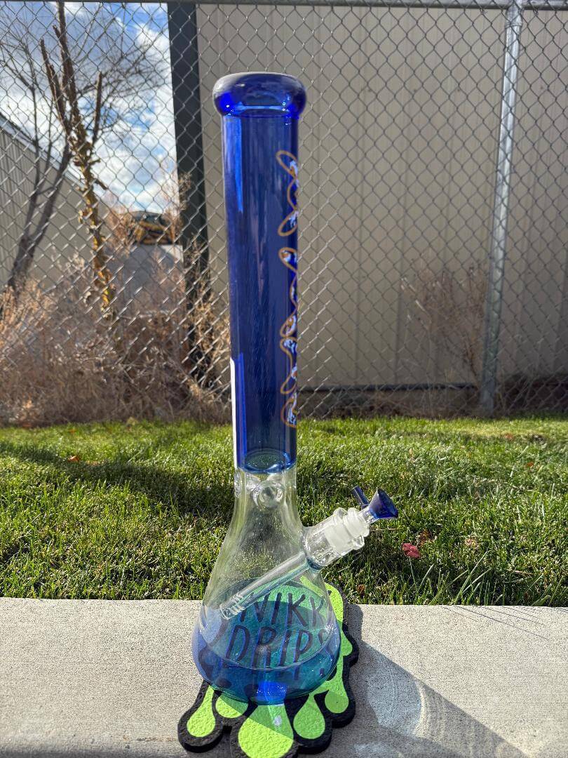 MAV Glass 18" Beaker 14mm 90° - Ink Blue Koi displayed outdoors on grass.