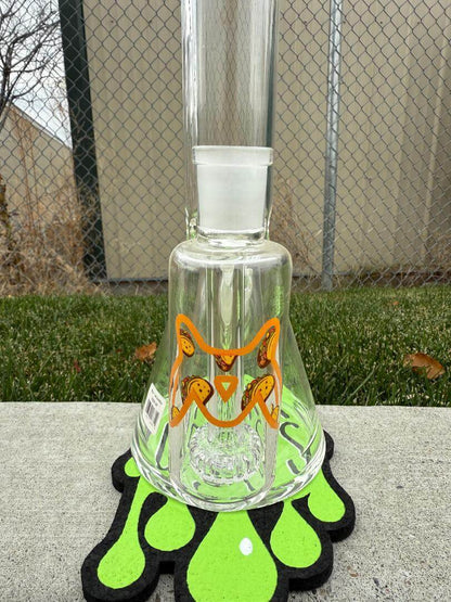 MAV Glass "18 Straight Tube Ash Catcher Combo - Taco" displayed with playful orange design on a decorative stand.