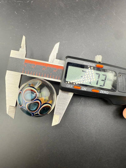 McDoogIe Glass Marble – 34mm Gold Fume Implosion with measuring calipers showing 34mm size.