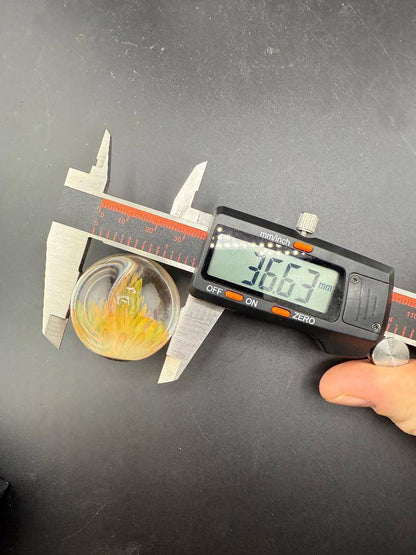 McDoogIe Glass Marble – 36mm Gold Fume Implosion shown with measurement caliper