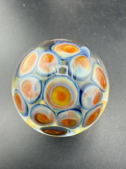 McDoogIe Glass Marble – 40mm Gold Fume Implosion showcasing vibrant colors and intricate design.
