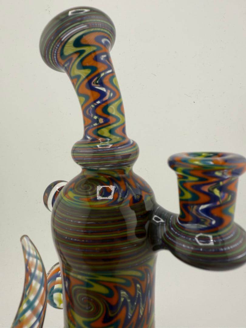 Mcdoogle Glass 10mm wig wag rig with vibrant teal, yellow, and orange colors, showcasing unique swirling linework.