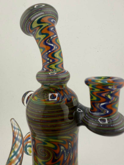 Mcdoogle Glass 10mm wig wag rig with vibrant teal, yellow, and orange colors, showcasing unique swirling linework.