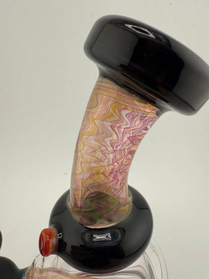 Close-up of Mcdoogle Glass Fumed Banger Hanger 10mm Rig showcasing vibrant swirled glass pattern and sleek black accents.