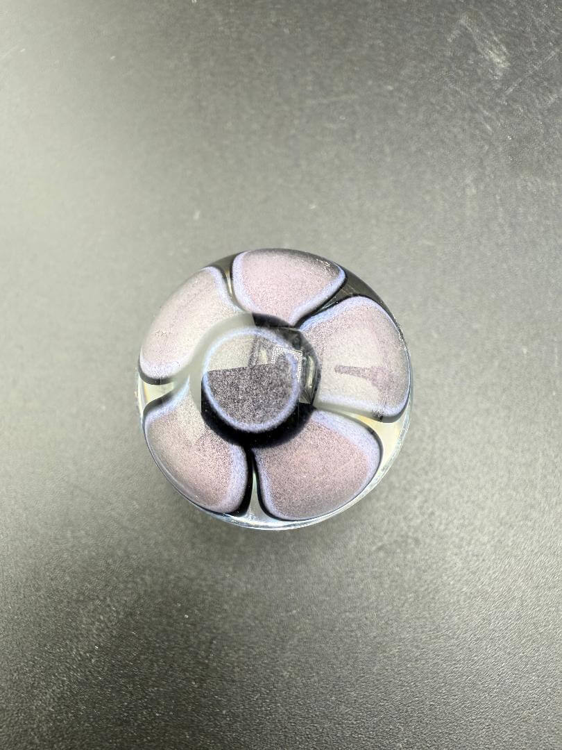 Mcdoogle Glass Marble - 22mm No Fume Fume Tech w/ Purple Flower Dot Stack Backer on black surface.