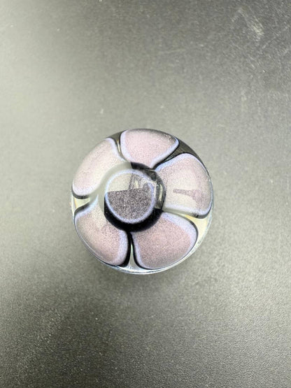 Mcdoogle Glass Marble - 22mm No Fume Fume Tech w/ Purple Flower Dot Stack Backer on black surface.