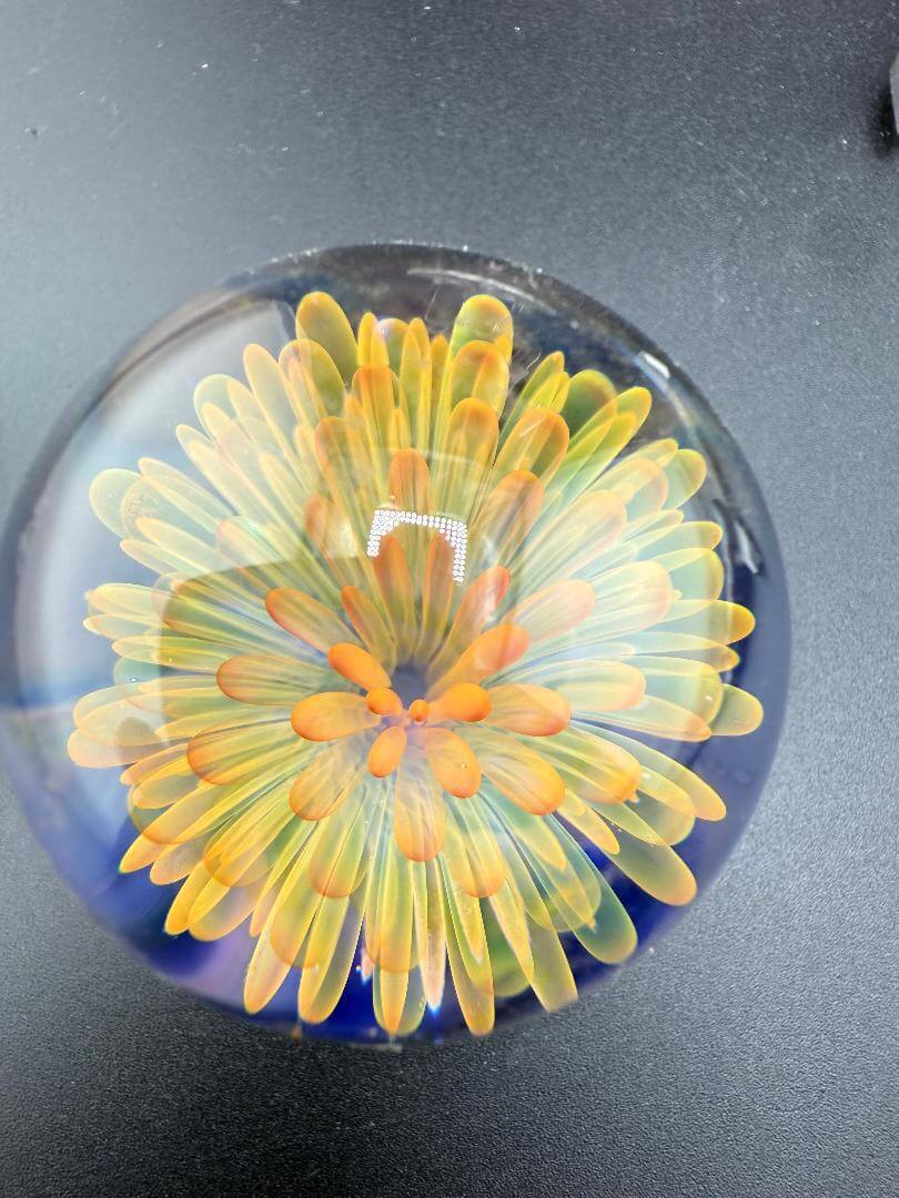 Mcdoogle Glass Marble - 40mm Gold Fume Implosion showcasing vibrant layered flower design.