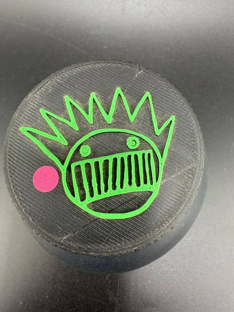 Close-up of McDoogle Glass Nug Jar lid featuring Boognish design in green on a black background.
