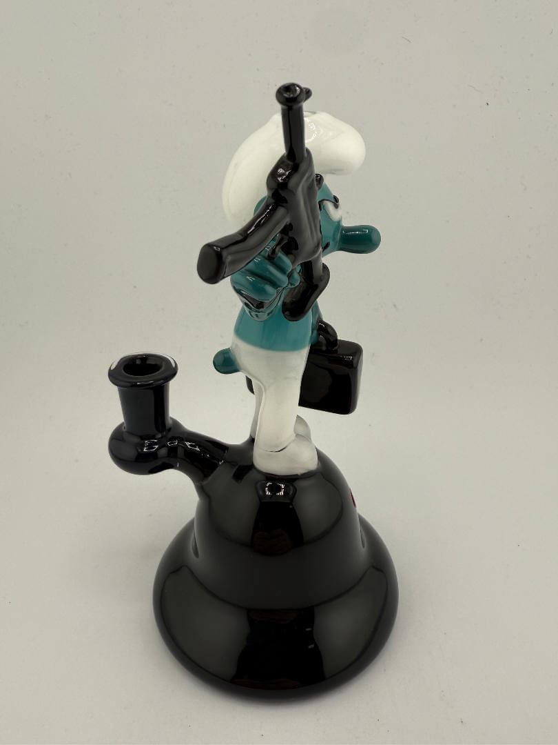 Mcdoogle Glass Smurf Rig with briefcase and machine gun, playful and detailed glass art piece.