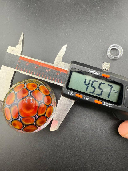 McDoogIe Glass Marble – 45mm Gold Fume Implosion being measured at 45.57mm with calipers.